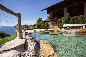un cortile con una piscina d'acqua di fronte a una casa di Eggerhof Suite a Verano