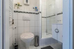 a white bathroom with a toilet and a shower at Ferienwohnung Harzblick in Altenau +16 photos