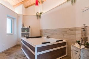 a bathroom with a large tub in the middle at Wellness Lodge Riccardo in Santa Giuliana +29 photos