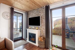ein Wohnzimmer mit Kamin und Flachbildfernseher in der Unterkunft Bergchalet 20 mit Sauna in Heringhausen