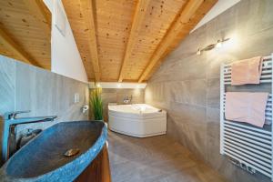 un bagno con lavandino e vasca da bagno di Eggerhof Suite a Verano
