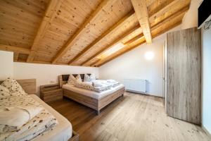 due letti in una stanza con soffitto in legno di Eggerhof Suite a Verano