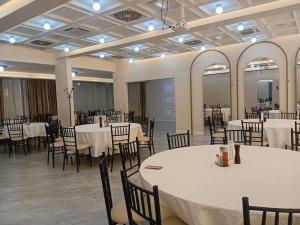 a banquet hall with white tables and chairs at Hotel Tiski Cvet in Novi Bečej