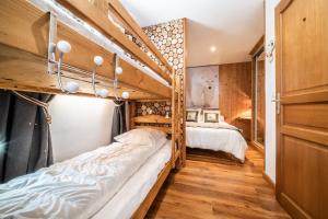 two bunk beds in a room with wooden walls at Au Rêve Savoyard 3 - 6 personnes in Morillon