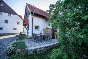 a patio with a table and chairs next to a building at Mühlenhof in Olbersdorf