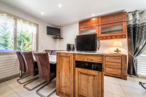 a kitchen with a table with a television and chairs at Au Rêve Savoyard 3 - 6 personnes in Morillon