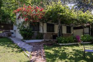 a house with a bench and flowers in the yard at El Castañar de Ceubia in Arenas de San Pedro