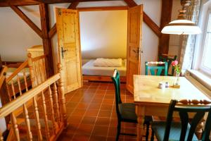 a dining room with a table and a bed at Mühlenhof in Olbersdorf