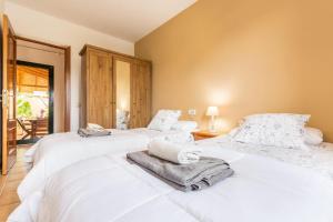 two white beds in a room with a balcony at Villa Orquidea in Tamaragua