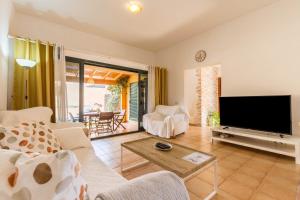 a living room with a large flat screen tv at Villa Orquidea in Tamaragua