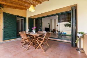 a dining room with a table and chairs on a patio at Villa Orquidea in Tamaragua +20 photos