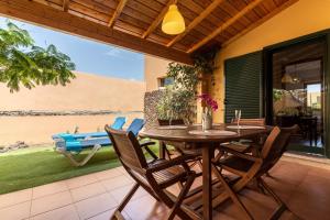 a wooden table and chairs on a patio at Villa Orquidea in Tamaragua