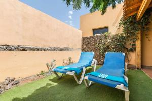 two chairs sitting on a lawn in front of a building at Villa Orquidea in Tamaragua