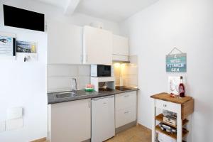 a kitchen with white cabinets and a sink at Apartamento La Morena 3a in El Pris +15 photos