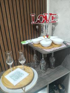 a table with two plates and wine glasses on a shelf at Suite San Giovanni in Gela
