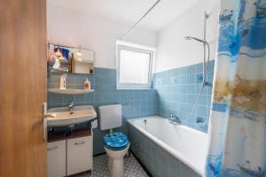 a bathroom with a sink and a toilet and a bath tub at Haus Schild in Grassau