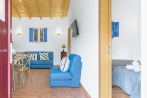 a living room with a blue chair and a table at Casa da Ti Mónica in São Luis