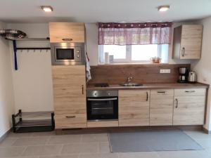 a kitchen with wooden cabinets and a sink at wohnung-nummer-1 in Pielenhofen +2 photos