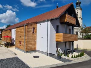 a small white and wooden building with a tower at wohnung-nummer-1 in Pielenhofen