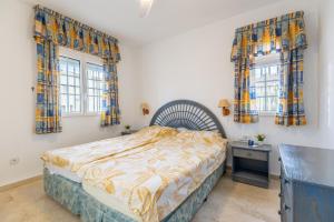 a bedroom with a bed and two windows at Las Ramblas in Orihuela +19 photos