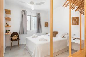 a white bedroom with a bed and a mirror at Marce in Ciutadella