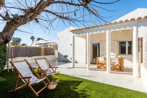 a patio with two chairs and a table in a yard at Marce in Ciutadella