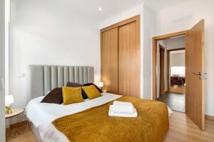 a bedroom with a large bed with yellow pillows at Traditional 3 bedroom apartment in Alte