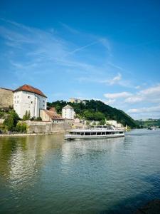 a boat traveling down a river near a castle at Cozy Corner - Passau in Passau