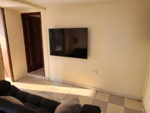 a living room with a couch and a flat screen tv at Apartamento FullLife in Zipaquirá