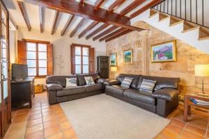 a living room with a leather couch and a table at Casa Romana in Pollença