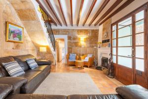 a living room with a couch and a fireplace at Casa Romana in Pollença +21 photos