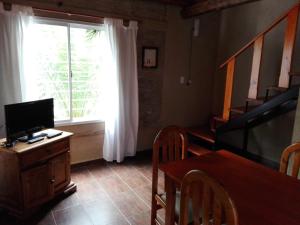 een woonkamer met een televisie, een tafel en een raam bij Villa Carlos Paz Alojamiento Santa Ponsa in Villa Carlos Paz