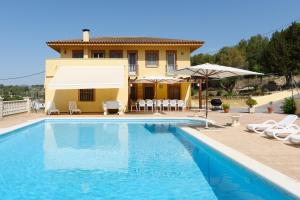 a villa with a swimming pool in front of a house at Cal Vimon in Las Masucas