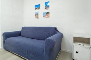 a blue couch in a room with pictures on the wall at I giardini di Cala D'ambra in San Teodoro