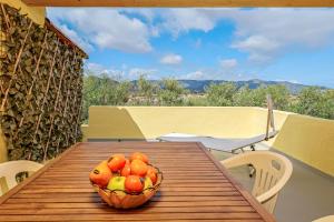 a bowl of fruit on a wooden table on a balcony at I giardini di Cala D'ambra in San Teodoro