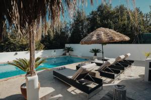 a pool with lounge chairs and an umbrella and a pool at Villa Carol in Illes Balears