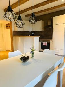 a kitchen with a white table and white chairs at Ferienwohnung Bauernpfad in Kressbronn am Bodensee