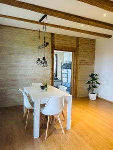 a white dining room with a white table and chairs at Ferienwohnung Bauernpfad in Kressbronn am Bodensee +14 photos