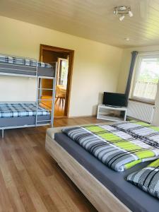 a bedroom with two bunk beds and a wooden floor at Ferienwohnung Bauernpfad in Kressbronn am Bodensee