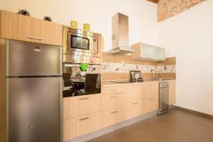 a kitchen with wooden cabinets and a stainless steel refrigerator at Casa Rural La Morisca in Tuineje