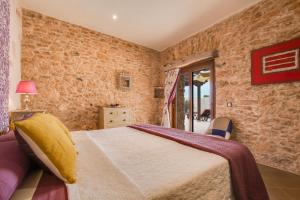 a bedroom with a large bed and a stone wall at Casa Rural La Morisca in Tuineje