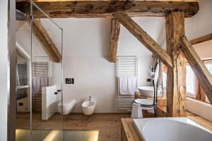 a bathroom with a tub and a toilet and a sink at Obereggeralm in Valdaora +22 photos