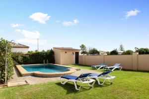 a backyard with a swimming pool and two lawn chairs at Villa Perez Zara 3 in Campano