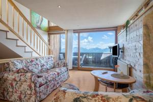 a living room with a couch and a table at Haus der Sinne Bregenzerwald in Tannen
