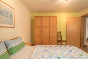 a bedroom with a bed and a closet and a chair at Sabinas Gästewohnung in Wasserburg