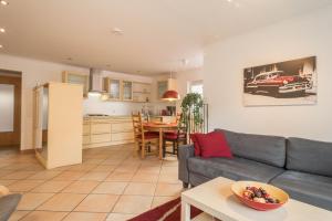 a living room and kitchen with a couch and a table at Sabinas Gästewohnung in Wasserburg