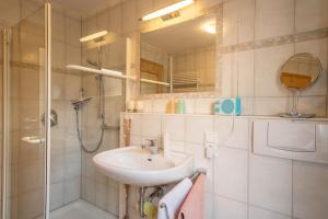 a bathroom with a sink and a shower and a mirror at Sabinas Gästewohnung in Wasserburg +11 photos