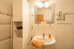 a white bathroom with a sink and a mirror at Ferienwohnung Nr 3 in Deggenhausertal +21 photos