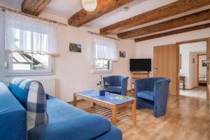 a living room with a blue couch and chairs and a table at Ferienwohnung Nr 3 in Deggenhausertal