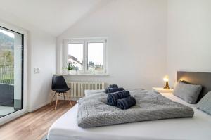 a white bedroom with a large bed and a window at Sonne und Mehr in Stockach